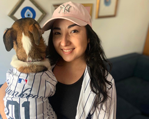 Photo of MARI SKOULTCHI holding her dog wearing NY yankees tee